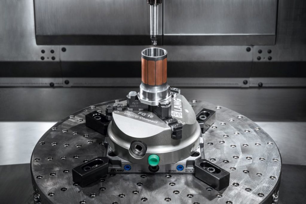 Bei diesem Rohling sind die Taschen mit Kupfer gefüllt. Im nächsten Schritt schließt die Maschine diese mit dem Auftragen von Stahl. Das Spannmittel, hier ein Ino-Grip-Compact-Dreibackenfutter von Lang Technik, muss auch die Temperaturen bis 300 °C und mehr aushalten und dabei maßhaltig und präzise bleiben. - Bild: Hermle