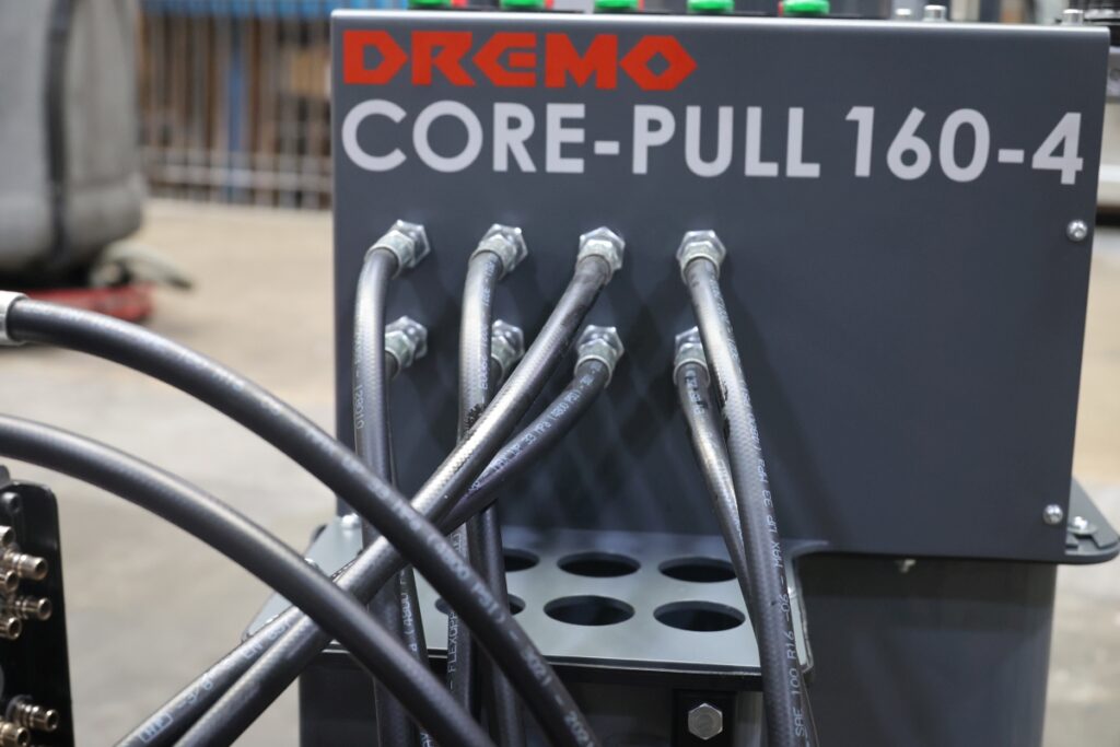 Intelligente Details am Kernzugaggregat Dremo „Core-Pull“160-4 zeigen die Herkunft aus der Werkstattpraxis: So können die Formenbauer bis zu acht Hydraulikschläuche an einer Vorrichtung einhängen. Deren Restinhalt kann dann kontrolliert in einen 6-l-Tank ablaufen. – Bild: Pergler Media